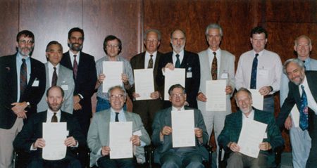 Un grupo de personas sosteniendo un trozo de papel y posando para una foto.